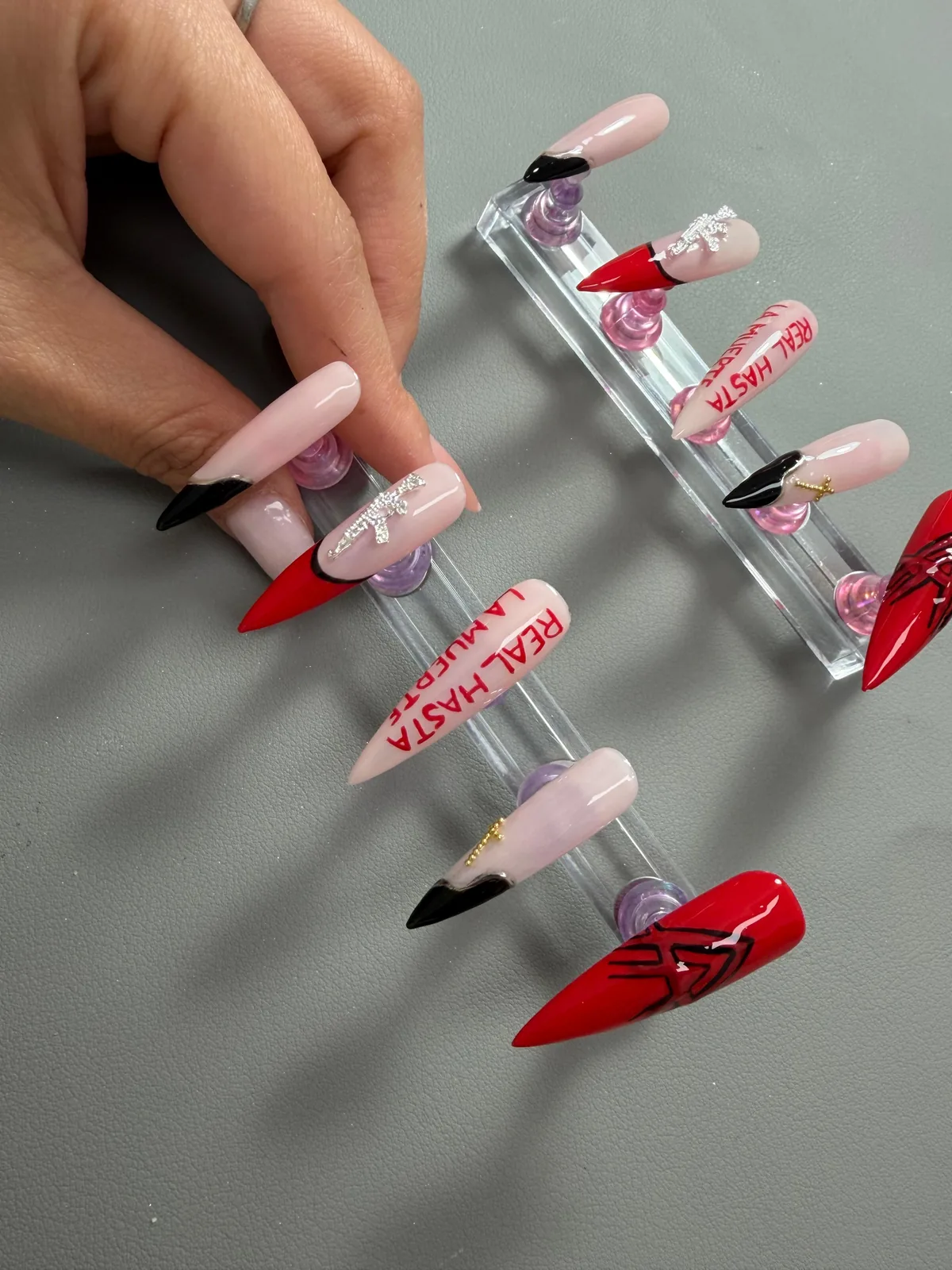 Lange nageltips met rood, roze en decoratieve details